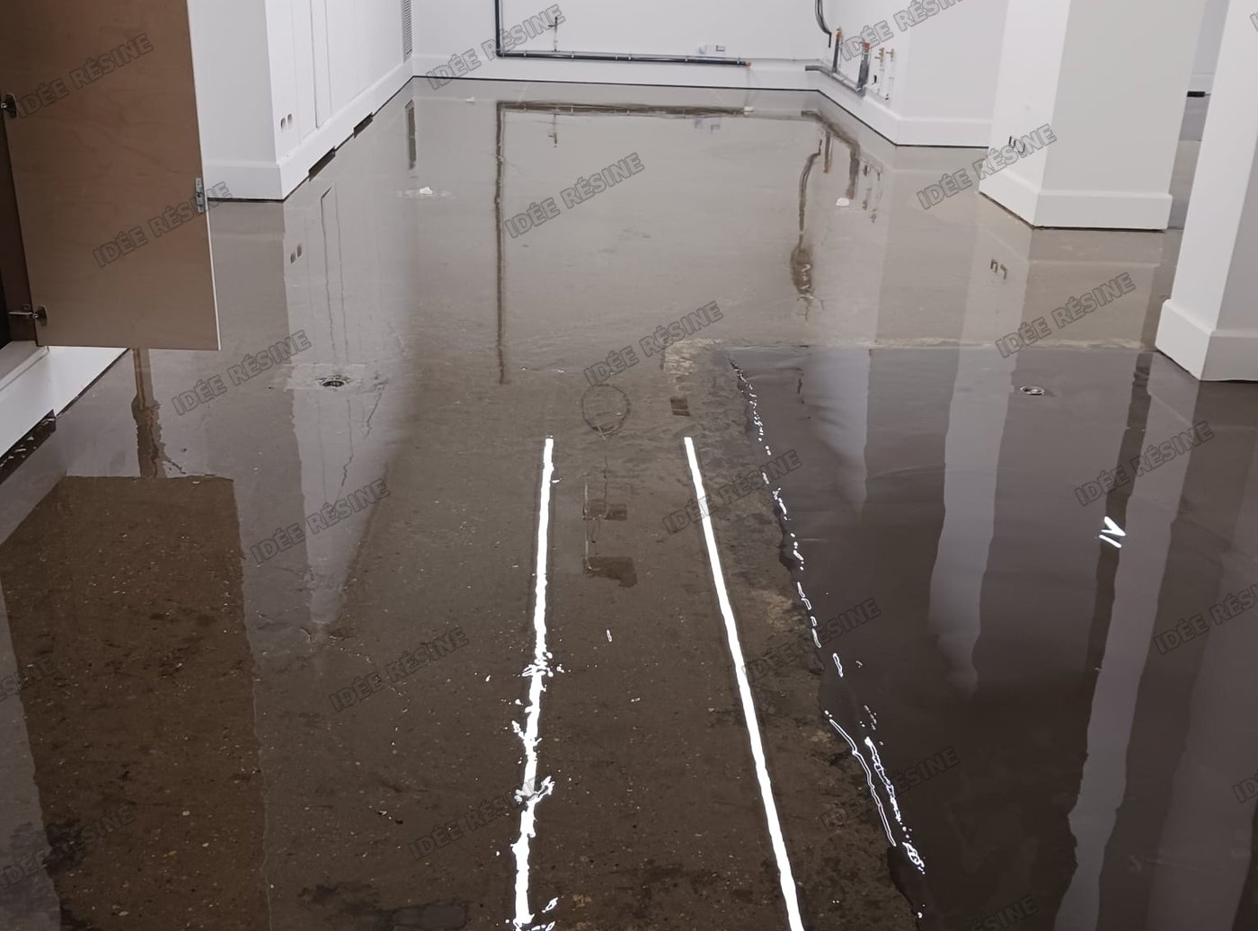 Application d’un système de résine autolissante sur un sol, chantier réel Idée Résine